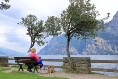 19 Mayıs 2023 - İtalya 'da Riva del Garda: bulutlu bir günde şehrin limanındaki insanlar