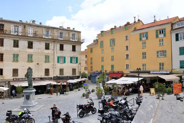 27 Mayıs 2023 - Corte, Fransa Korsika Adası: Korsika 'nın Corte şehrinin tarihi şehir merkezinde yürüyen turistler dağlarla çevrili