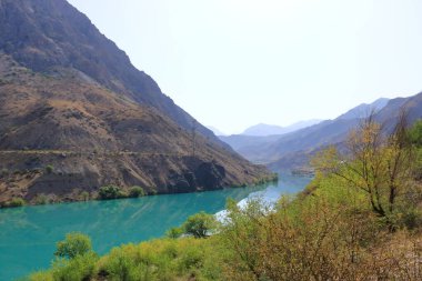 Güneşli bir günde güzel dağ manzarası. Dağlardaki Naryn Nehri 'nin turkuaz suyu Toktogul, Kırgızistan, Orta Asya' ya yakın.