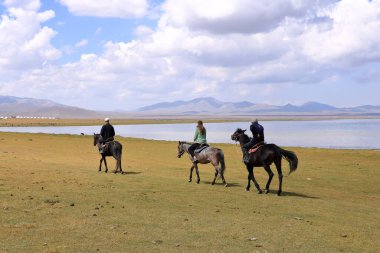 25 Ağustos 2023 - Kırgızistan 'daki Song Kol Gölü: İnsanlar dinleniyor ve gölün çevresindeki doğanın tadını çıkarıyor