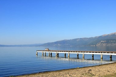 11 Eylül 2023 - Arnavutluk 'ta Tushemisht, Pogradec: Ohri Gölü kıyılarında yaz sonlarında bazı insanlar ve tekneler