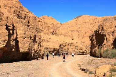 27 Ağustos 2023 - Kırgızistan 'da Aksai, Aksay: İnsanlar Issyk Kul Gölü' ndeki kanyon oluşumunun keyfini çıkarıyorlar