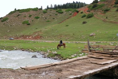 28 Ağustos 2023 - Kırgızistan 'ın Issyk-Kul Bölgesi, Jeti Oğuz: bulutlu bir günde dağlarda at süren yerliler