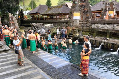 Tampak Siring, Tampaksiring, Bali in Indonesia - January 31 2024: people take a bath in the Tirta Empul temple (Holy Spring Water Temple) clipart