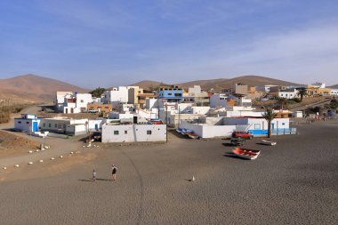 November 20 2023 - Ajuy, Fuerteventura in Spain: Ajuy village with colourful houses and fishing boats on the black sand of the beach clipart