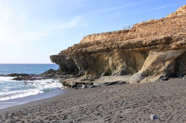 İspanya 'nın Fuerteventura bölgesinin batı kıyısındaki siyah volkanik kum ve taşlardan oluşan Ajuy plajı.