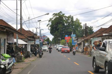 Ubud, Endonezya 'da Bali - 31 Ocak 2024: Bali sokaklarında arabalar ve motorsikletler