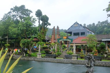 Bali, Endonezya - Şubat 05 2024: İnsanlar yağmurlu bir günde Doğu Bali 'deki Tirta Gangga Su Sarayı' nın tadını çıkarıyor