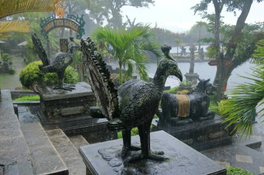 Bali, Endonezya - Şubat 05 2024: İnsanlar yağmurlu bir günde Doğu Bali 'deki Tirta Gangga Su Sarayı' nın tadını çıkarıyor