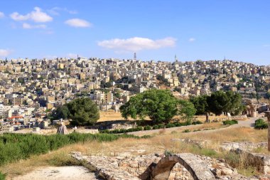 Amman in, Jordan - 07 Mayıs 2024: Kum taşı binalara ve öğleden sonra ana yollara bakan şehir manzarası