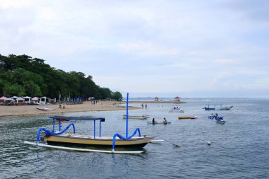 Sanur, Endonezya 'dan Bali - Şubat 08 2024: İnsanlar öğleden sonra plajın keyfini çıkarıyorlar