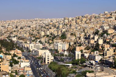 Amman in, Jordan - 07 Mayıs 2024: Kum taşı binalara ve öğleden sonra ana yollara bakan şehir manzarası