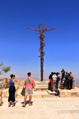 Ürdün 'deki Nebo Dağı - 09 Mayıs 2024: İnsanlar Musa' nın kutsal toprakları gördüğü Nebo Dağı 'nın tepesindeki Yılan Haçı' nı ziyaret ediyor.