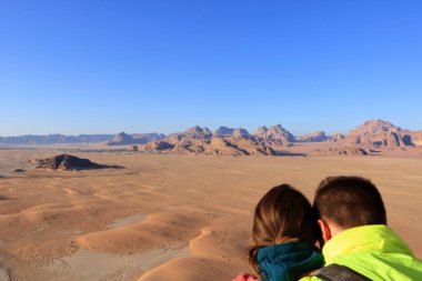 Ürdün 'deki Wadi Rum - 16 Mayıs 2024: İnsanlar ünlü Wadi Rum çölünde, dağların tepesinde sıcak hava balonunun keyfini çıkarıyorlar.