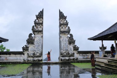 Bali in Indonesia - February 05 2024: people visit and enjoy the Lempuyang Luhur temple in Bali on a rainy day clipart