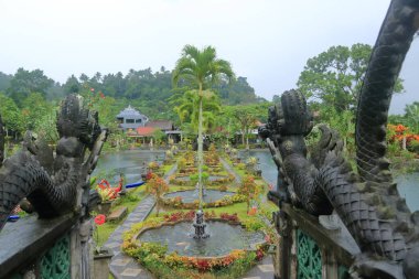 Bali, Endonezya - Şubat 05 2024: İnsanlar yağmurlu bir günde Doğu Bali 'deki Tirta Gangga Su Sarayı' nın tadını çıkarıyor