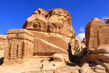 Ürdün 'de Petra, Wadi Musa - 13 Mayıs 2024: İnsanlar Cin bloklarını ziyaret ediyor, üç devasa, çömelmiş anıt, antik Petra kentinin girişinde yol kenarında nöbet tutuyorlar.