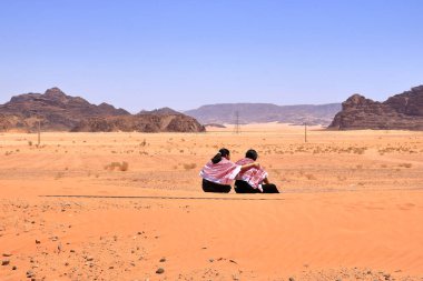 Ürdün 'deki Wadi Rum - 15 Mayıs 2024: İnsanlar neredeyse tamamen çöl kumuyla kaplı eski tren raylarını ziyaret ediyor.