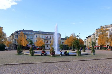 October 30 2023 - Potsdam in Germany: fountain at Luisenplatz near the of Brandenburg Gate in autumn. Tourists nearby clipart