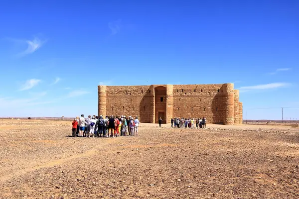 stock image Qasr Kharana in Jordan - May 08 2024: people visit the desert castle in eastern Jordan (sometimes Harrana, al-Kharanah, Kharaneh, Kharana or Hraneh)