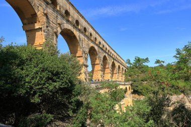 Provence, Fransa Avrupa - 25 Ağustos 2024: İnsanlar Fransa 'nın güneyindeki ünlü Roma su kemeri Pont du Gard' ı ziyaret edip eğleniyorlar.