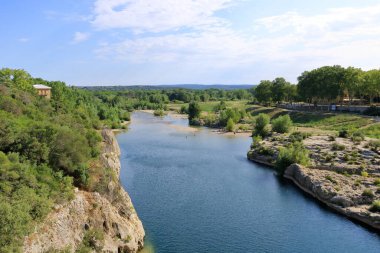 Provence, Fransa Avrupa - 25 Ağustos 2024: İnsanlar Fransa 'nın güneyindeki ünlü Roma su kemeri Pont du Gard' daki Gardon nehrini ziyaret edip eğleniyorlar.