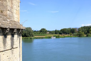 Barthelasse Mekik Hattı Quay Şehir Merkezi Sahili, Fransa 'nın Avignon kentindeki Pont Saint Benezet köprüsünün yanından geçen bir tekne.