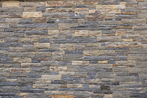 Стена из кирпича. Каменная облицовочная стена из природных серых камней
