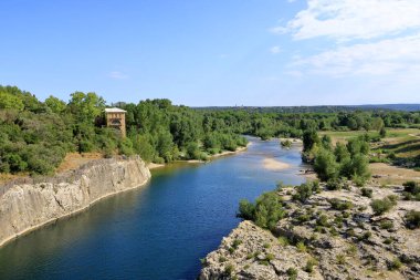 Provence, Fransa Avrupa - 25 Ağustos 2024: İnsanlar Fransa 'nın güneyindeki ünlü Roma su kemeri Pont du Gard' daki Gardon nehrini ziyaret edip eğleniyorlar.