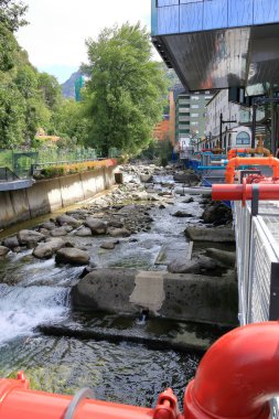 Les Escaldes - Engordany in Andorra - August 31 2024: The Caldes Art project with pipes and faucets at the River Valira clipart