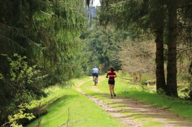 Flaje Çek Cumhuriyeti - 28 Nisan 2024: Çakıl yolunda koşan kadın ve erkek bisikletçi