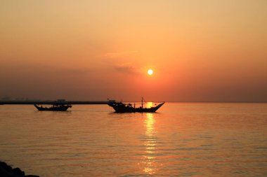 Orta Doğu 'daki Kuveyt' te gün batımının önünde balıkçı teknesi