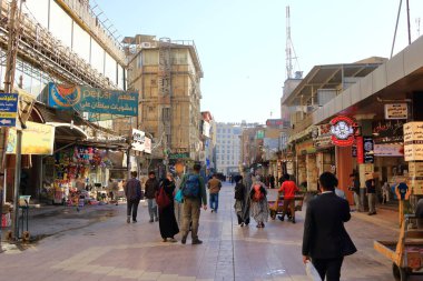 Necef, Nadscu Irak 'ta - 13 Kasım 2024: Seyyahlar güneşli bir günde şehirde yürüyor