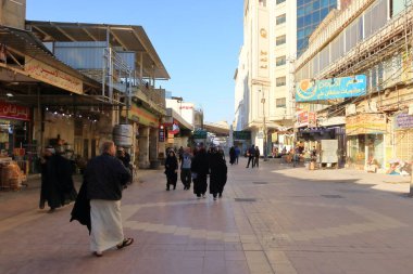 Necef, Nadscu Irak 'ta - 13 Kasım 2024: Seyyahlar güneşli bir günde şehirde yürüyor