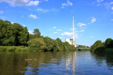 Saarbruecken, Saarland, Almanya - Ağustos 06 2024: Saar Nehri 'nden görülen elektrik santrali Heizkraftwerk Roemerbruecke