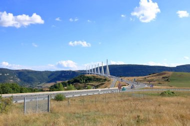 Millau, Fransa, Avrupa - 02 Eylül 2024: Çoklu gerilim kablosundan geçen arabalar Tarn Nehri vadisinde Millau Viaduct olarak kaldı