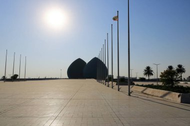 Baghdad, Bagdad in Iraq - November 14 2024: Split turquoise domes of Al Shaheed war memorial also called as Martyr's monument at the centre of the two half-domes is the Iraqi flag clipart