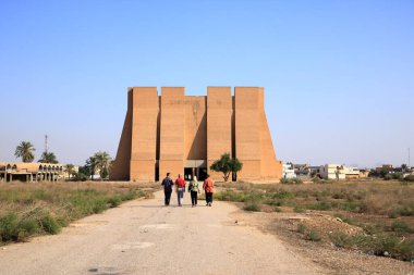 Ctesiphon, Baghdad, Bagdad in Iraq - November 14 2024: people at the building in opposite of the Ktesifon Palace or Tak-i Kisra - Taq Kasra, was used as a cinema, propaganda and culture center of Saddam Hussein clipart