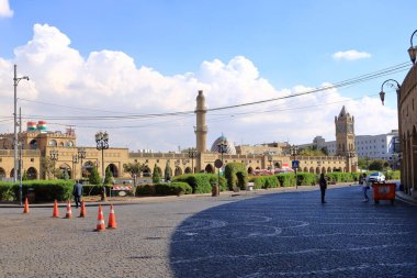Erbil, Erbil, Kürdistan, Irak - 20 Kasım 2024: Şehir merkezindeki Şah Parkı 'nda saat kulesinin yanında dinlenen insanlar, Parki Sar