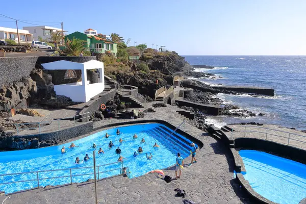 La Caleta, El Hierro, İspanya 'daki Kanarya Adaları - Aralık 04 2024: insanlar kıyı manzarası ve havuzlarının tadını çıkarıyorlar.