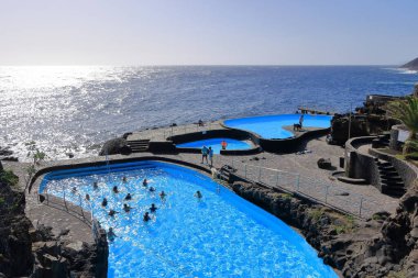 La Caleta, El Hierro, İspanya 'daki Kanarya Adaları - Aralık 04 2024: insanlar kıyı manzarası ve havuzlarının tadını çıkarıyorlar.