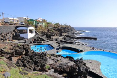 La Caleta, El Hierro, İspanya 'daki Kanarya Adaları - Aralık 04 2024: insanlar kıyı manzarası ve havuzlarının tadını çıkarıyorlar.