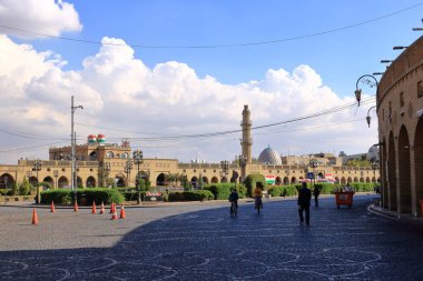 Erbil, Erbil, Kürdistan, Irak - 20 Kasım 2024: Şehir merkezindeki Şah Parkı 'nda saat kulesinin yanında dinlenen insanlar, Parki Sar