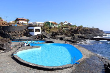 La Caleta, El Hierro, İspanya 'daki Kanarya Adaları - Aralık 04 2024: insanlar kıyı manzarası ve havuzlarının tadını çıkarıyorlar.