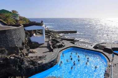 La Caleta, El Hierro, İspanya 'daki Kanarya Adaları - Aralık 04 2024: insanlar kıyı manzarası ve havuzlarının tadını çıkarıyorlar.