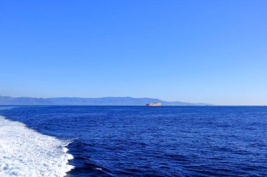 Cebelitarık Boğazı - 17 Şubat 2025: Arkasında İspanyol dağları olan bir konteyner gemisi