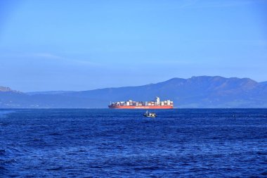 Cebelitarık Boğazı - 17 Şubat 2025: Arkasında İspanyol dağları olan bir konteyner gemisi