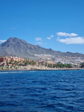 Tenerife 'de manzaralı bir yat gezisi, kıyı şeridinde yükselen Teide volkanı manzarası sunuyor, kristal berrak sular ve parlak mavi bir gökyüzü, keşif ve rahatlama günü için mükemmel.