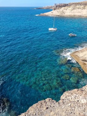Kanarya Adaları 'ndaki Cala de las Tortugas sakin ve uzak bir sahil deneyimi sunuyor. Kristal gibi berrak sularıyla, körfezde yavaşça yüzen küçük tekneler.