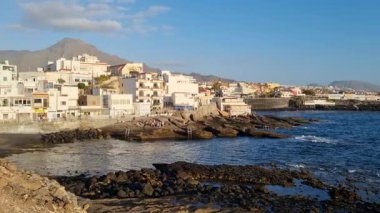 Sakin okyanusta yüzen bir yatla Tenerife Körfezi 'nin rahatlatıcı manzarası sahil boyunca büyüleyici bir sahil kasabası ve uzaktaki etkileyici Teide volkanı..